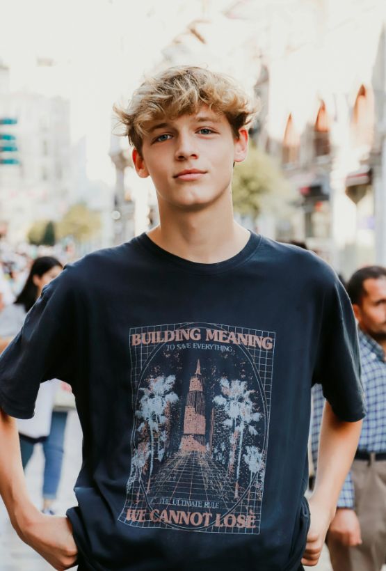 A Young Man Wearing A Custom-Printed Black T-Shirt, Showcasing The Result Of A Successful Bulk Apparel Order.
